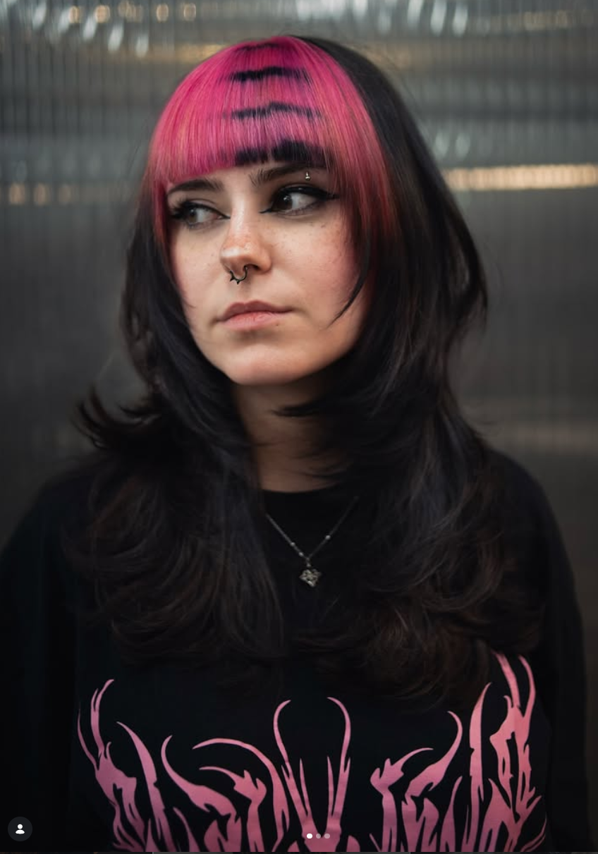 Flequillo fucsia con cabello negro, estética rock alternativa